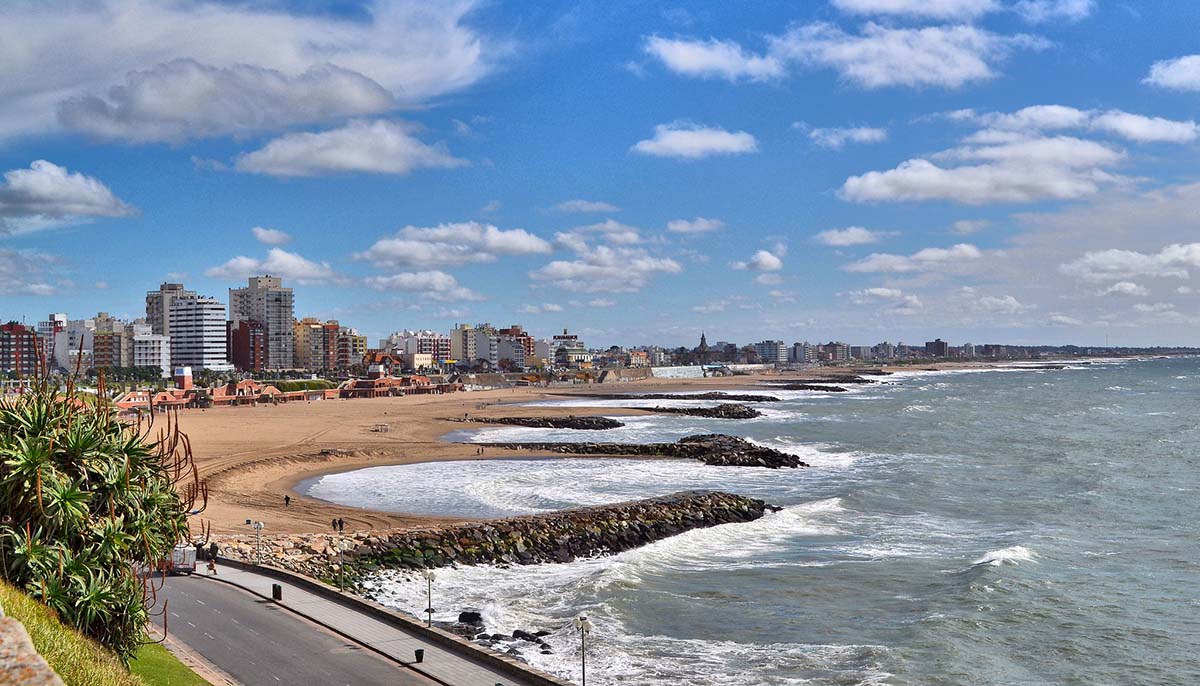 The sandy coast and sea of Mar del Plata on a partly cloudy day, a popular beach town in Argentina.