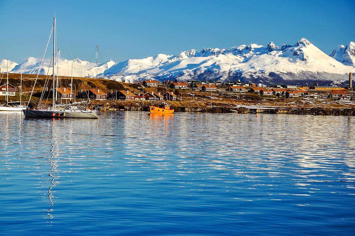 Sailboats in the waters near Ushuaia in Patagonia with snowcapped mountains overhead.