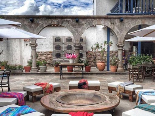 A table and benches in the courtyard of El Mercado Boutique Hotel in Cusco.