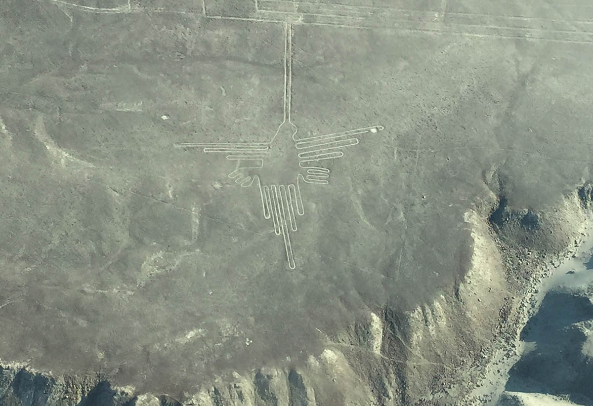 A large scale hummingbird shaped Nazca Line drawing in the sand as seen from above. 