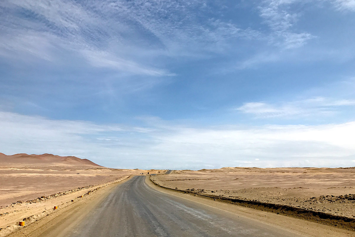 Hard-packed dirt road in the Paracas National Reserve surrounded by expansive desert. 