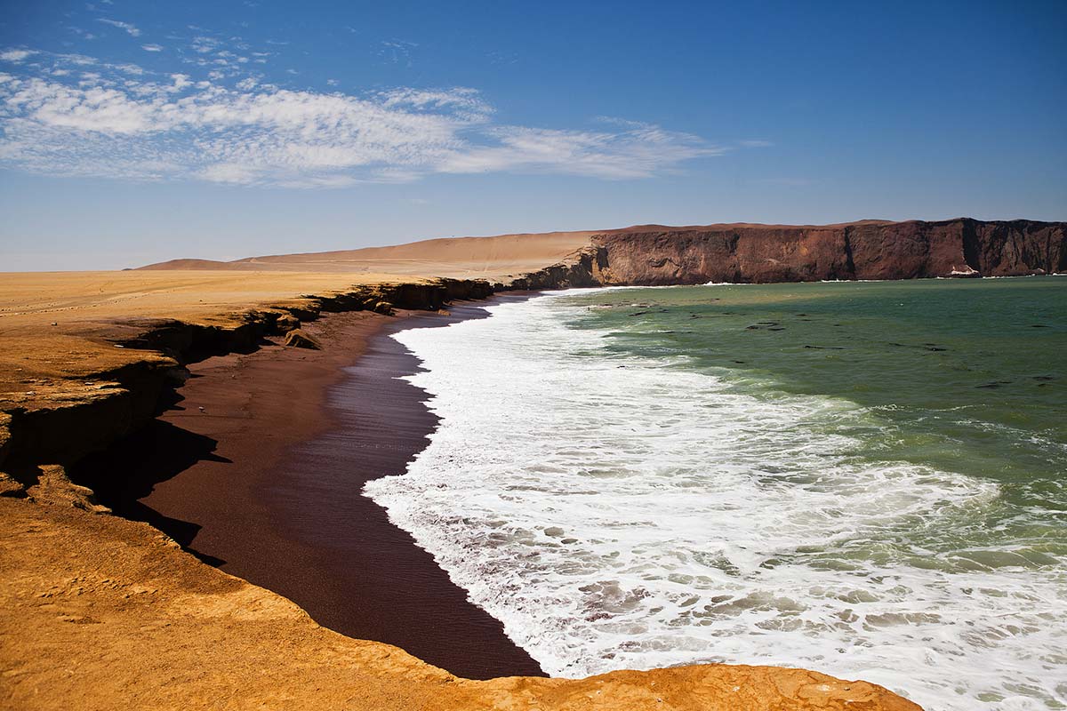 The crescent shaped Playa Roja with red sand in the Paracas National Reserve in Peru. 