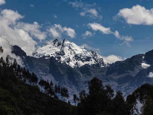 Dramatic snow covered peak covered with some clouds as viewed in the Sacred Valley in Peru.