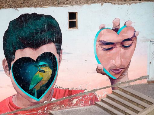 A mural in Barranco of a man removing a heart-shaped piece of his face to reveal a bird underneath.