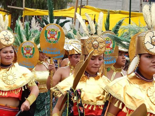 Performers wearing gold and red costumes and headdresses at carnival in the city of Cajamarca.