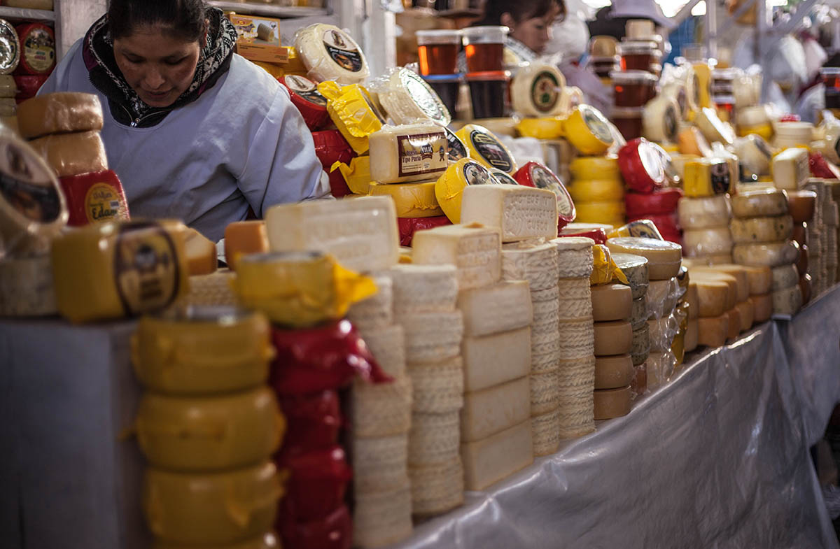 Ladies sell stacks of Andean cheese at the San Pedro Market in Cusco.