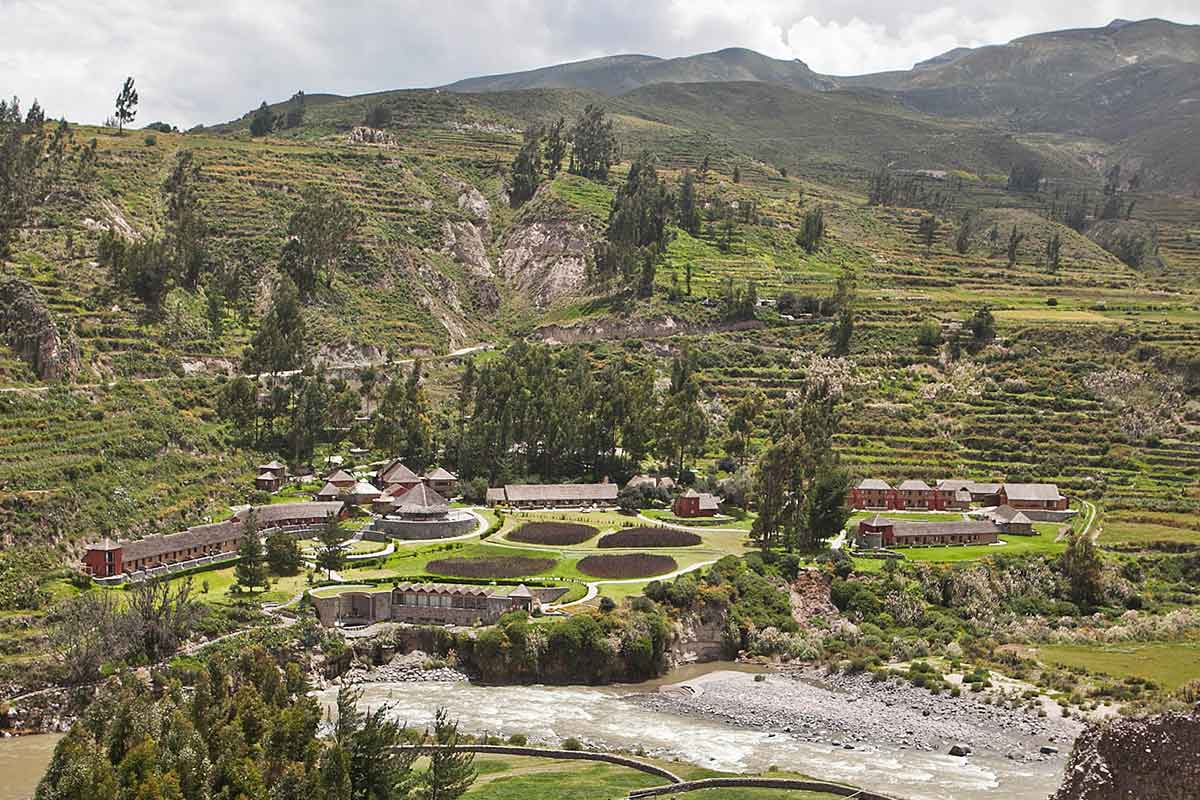 Looking down over the riverfront property of Colca Lodge in the green valley surrounded by terraces.