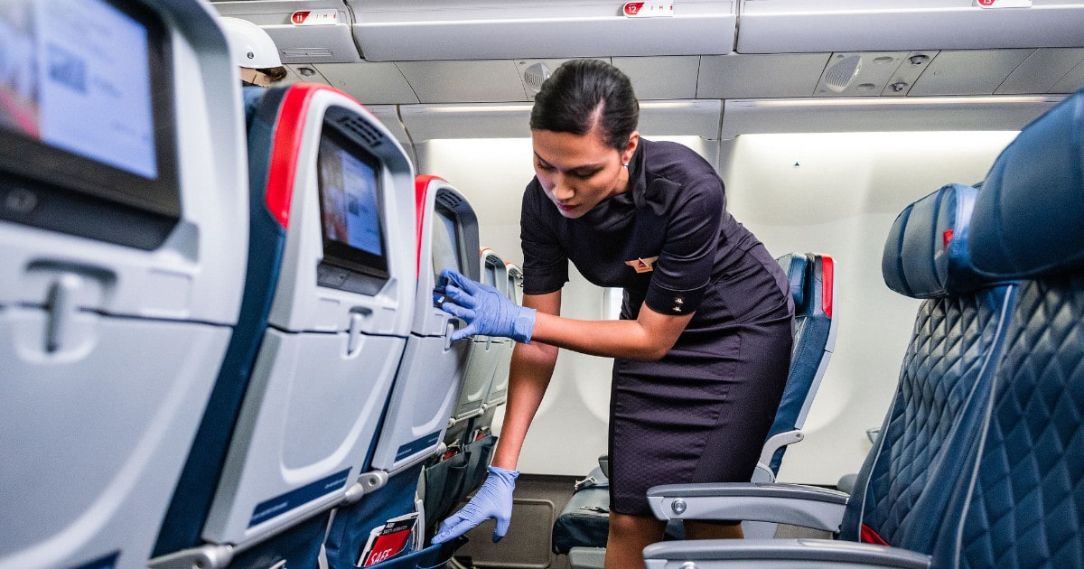 Woman cleans a Delta Airlines plane before the next flight to minimize the spread of Coronavirus.
