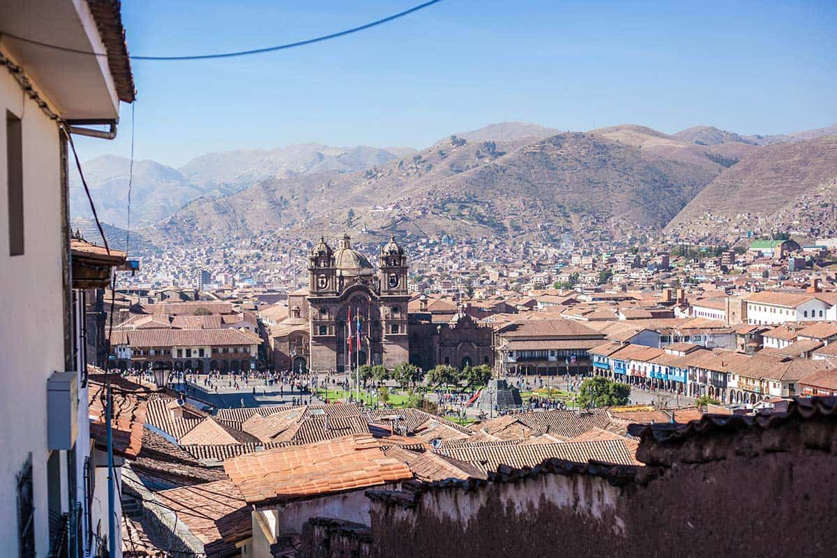 The expansive main plaza of Cusco surrounded by colonial brick buildings.