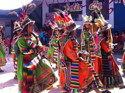 Dancers wearing colorful traditional clothing and performing a traditional dance in Cusco.