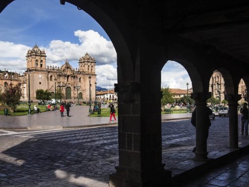 The main plaza in Cusco as seen from behind a few stone pillars.