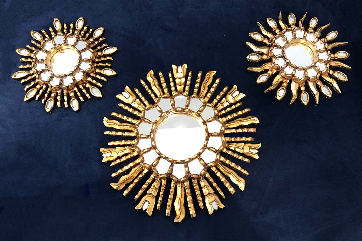 Three decorative Peruvian mirrors in a golden Inca sun style.