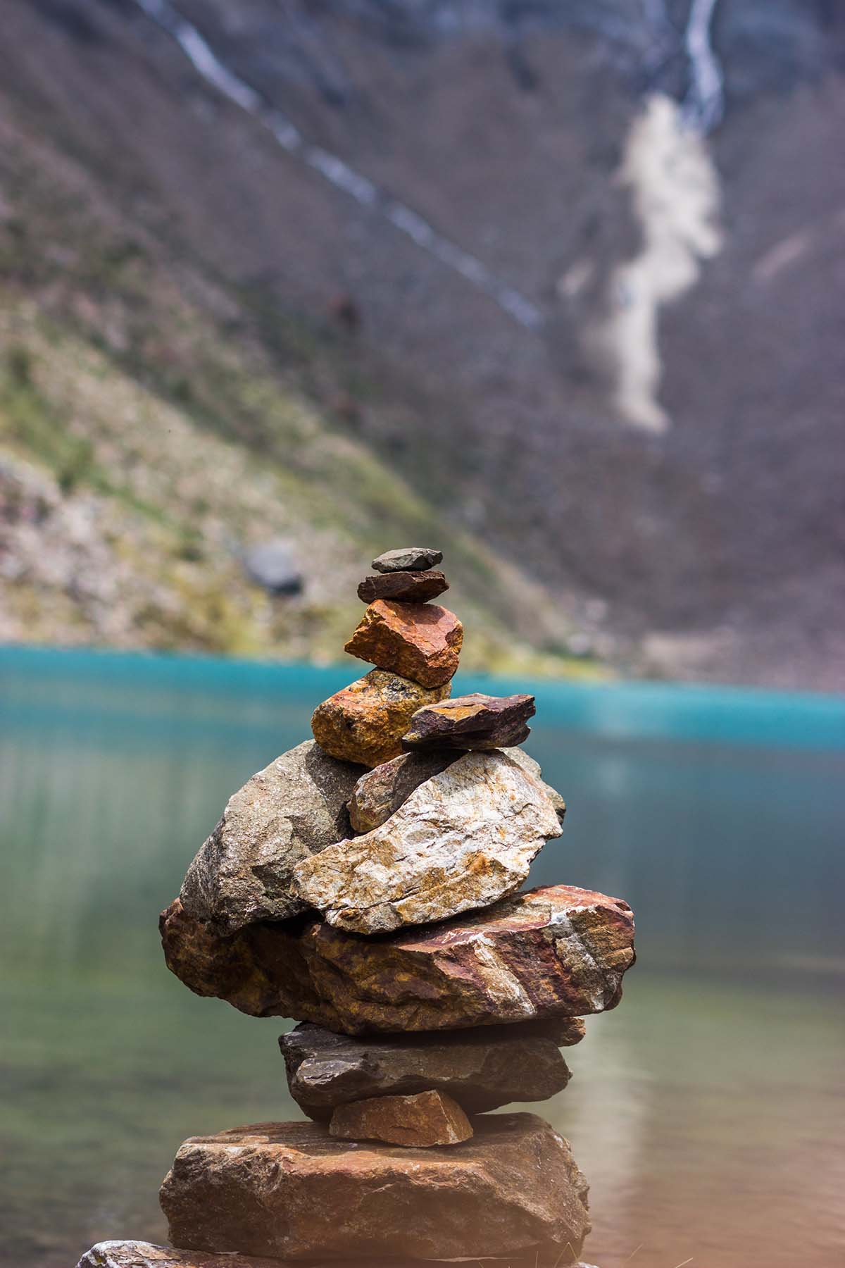 A stack of flat rocks make an "hito de piedra" along the shores of Lake Humantay near Cusco.
