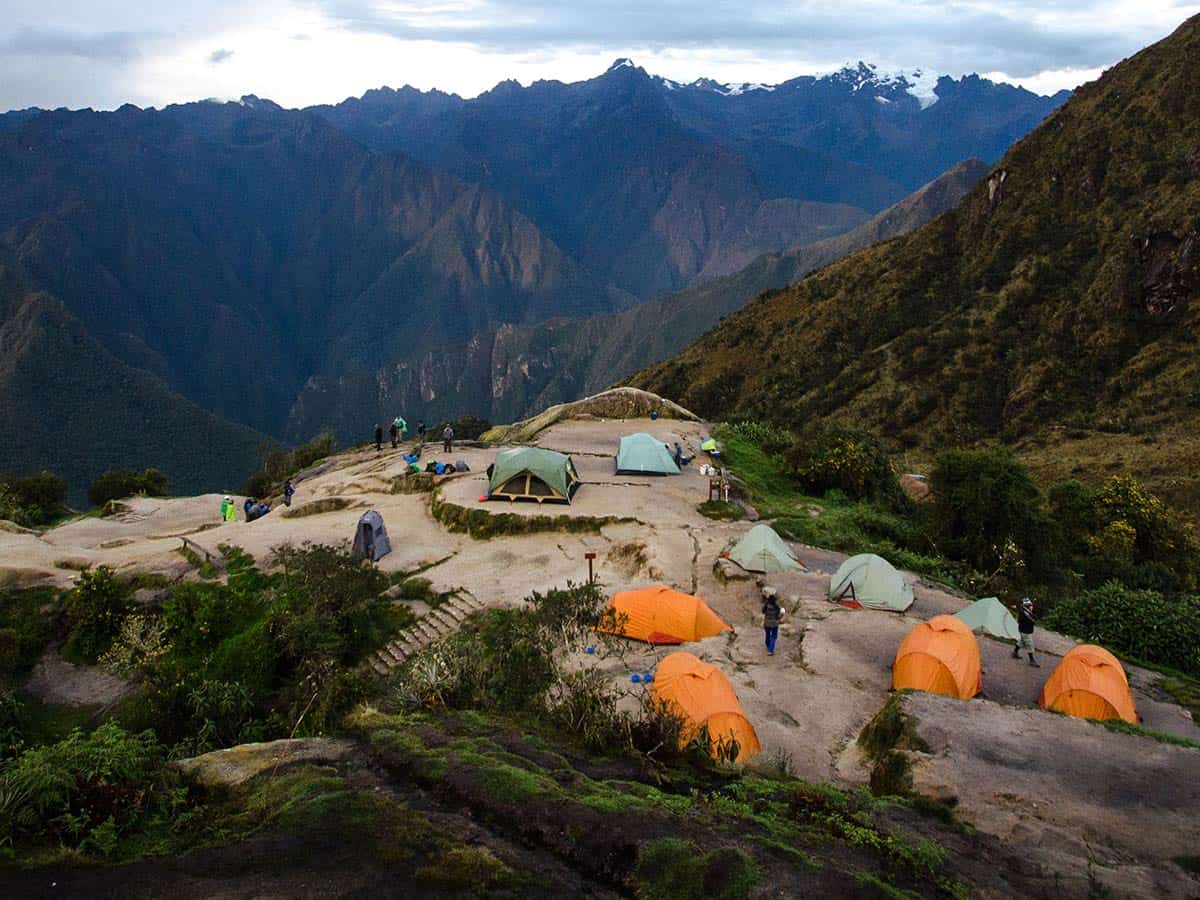 campsite with yellow and green tents overlooking mountains