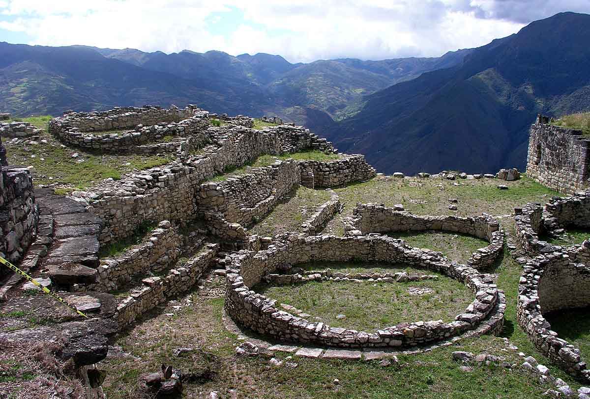 The sun shines over the stone ruins in circular shapes at Kuelap.