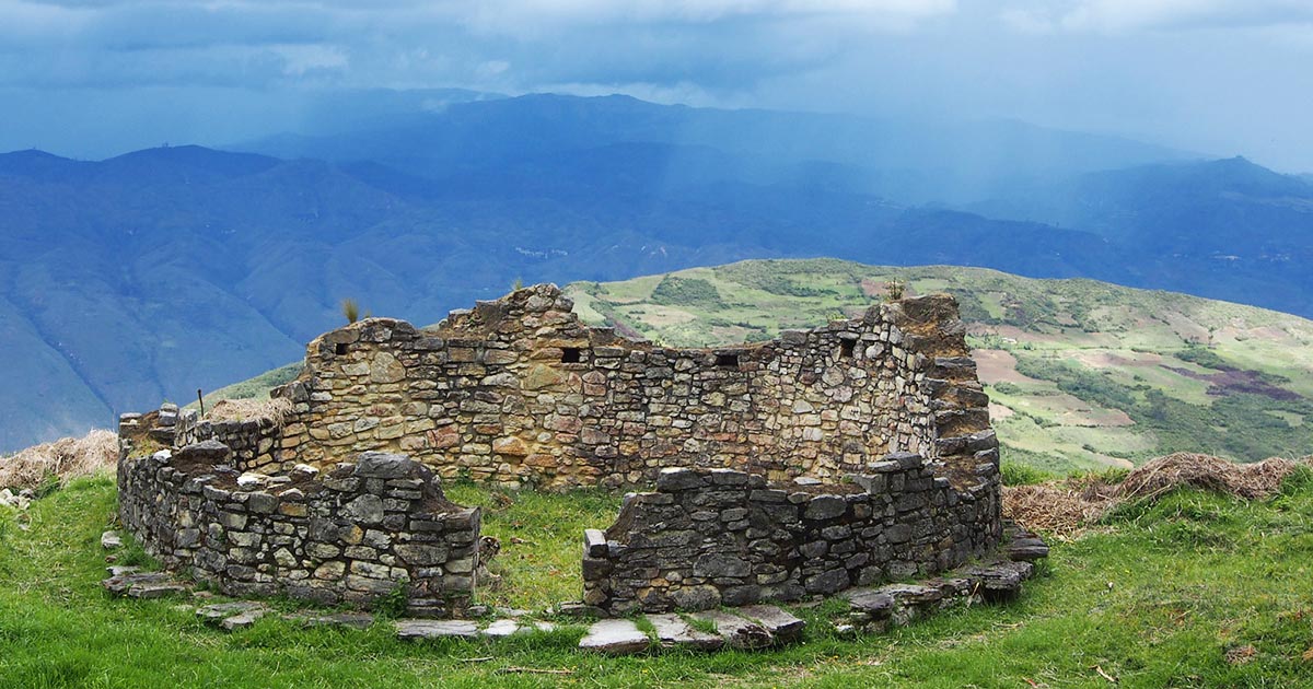 A circular stone house weathered away in time at the Kuelap Fortress in Peru.