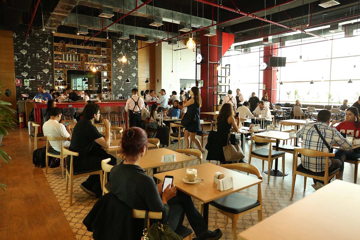 Clients and wait staff sitting and walking in La Nacional, a restaurant in the Lima airport.