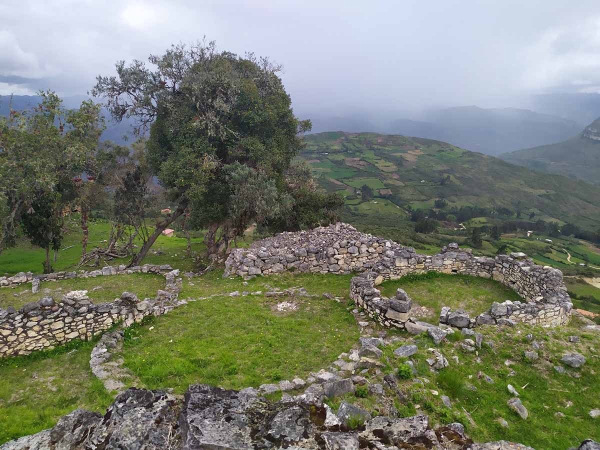 Stones in the grass placed in round shapes are what remain from the ancient Kuelap Fortress.