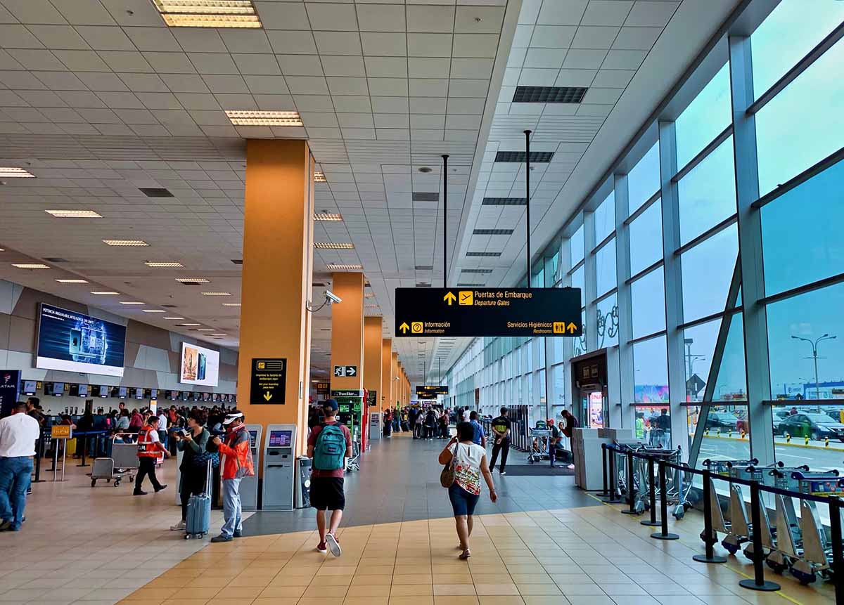 People walking through the check in hall at the Lima airport.