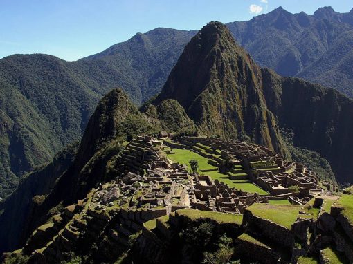 A view of Machu Picchu in Peru, iconic Inca ruins at the top of a jungle covered mountain.