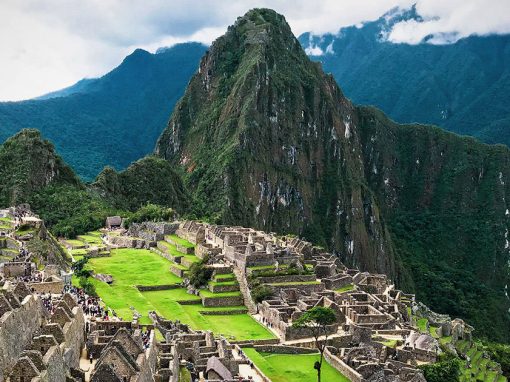 The iconic Inca ruins of Machu Picchu and surrounding mountains as seen from a lookout point.