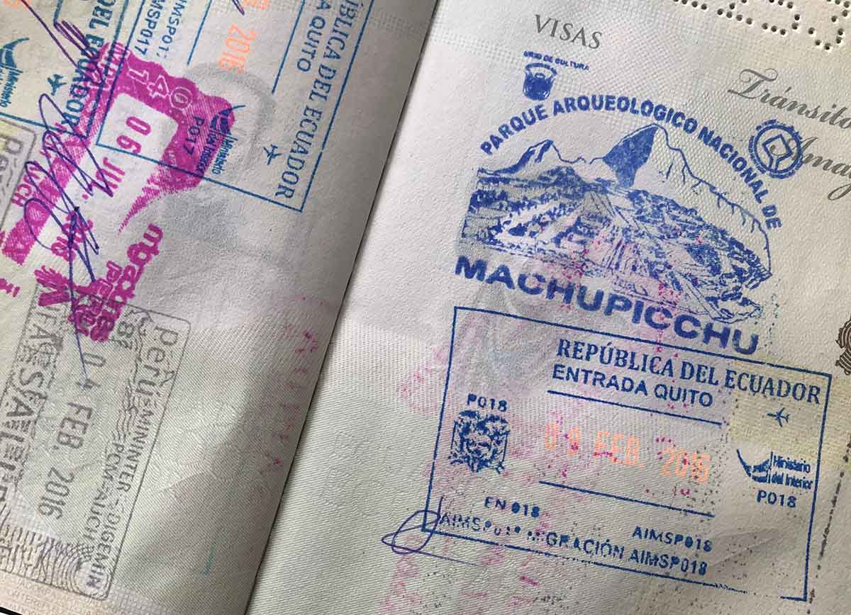 A passport with the blue Machu Picchu stamp, as well as Peruvian and Ecuadorian immigration stamps.