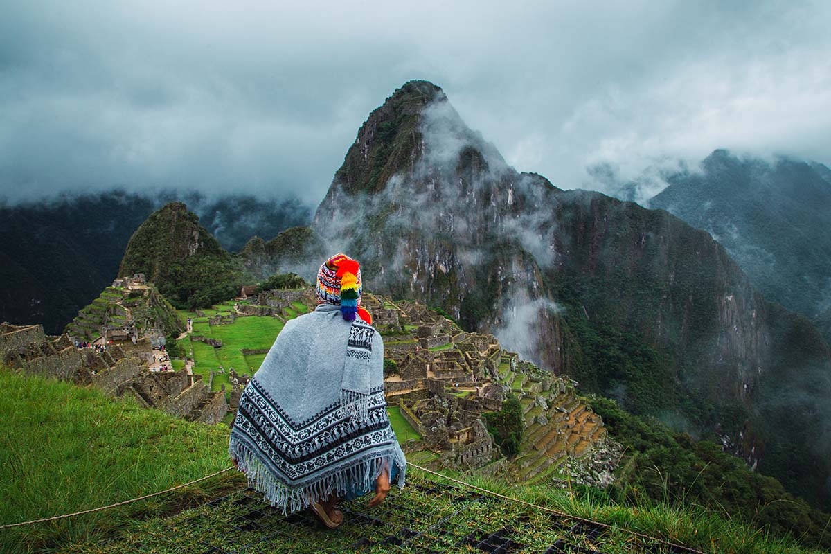 Machu Picchu viewed by traveller wearing colorful peruvian textiles