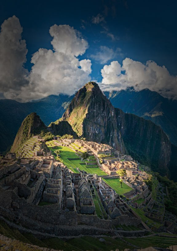 Overlooking the Incan citadel Machu Picchu surrounded by mountains with clouds in the sky