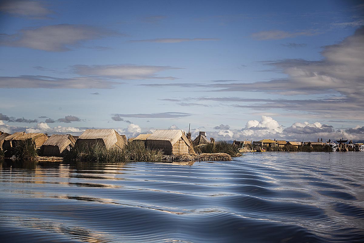 Ripples streak across Lake Titicaca where the Uros's Floating Islands sit in the background.