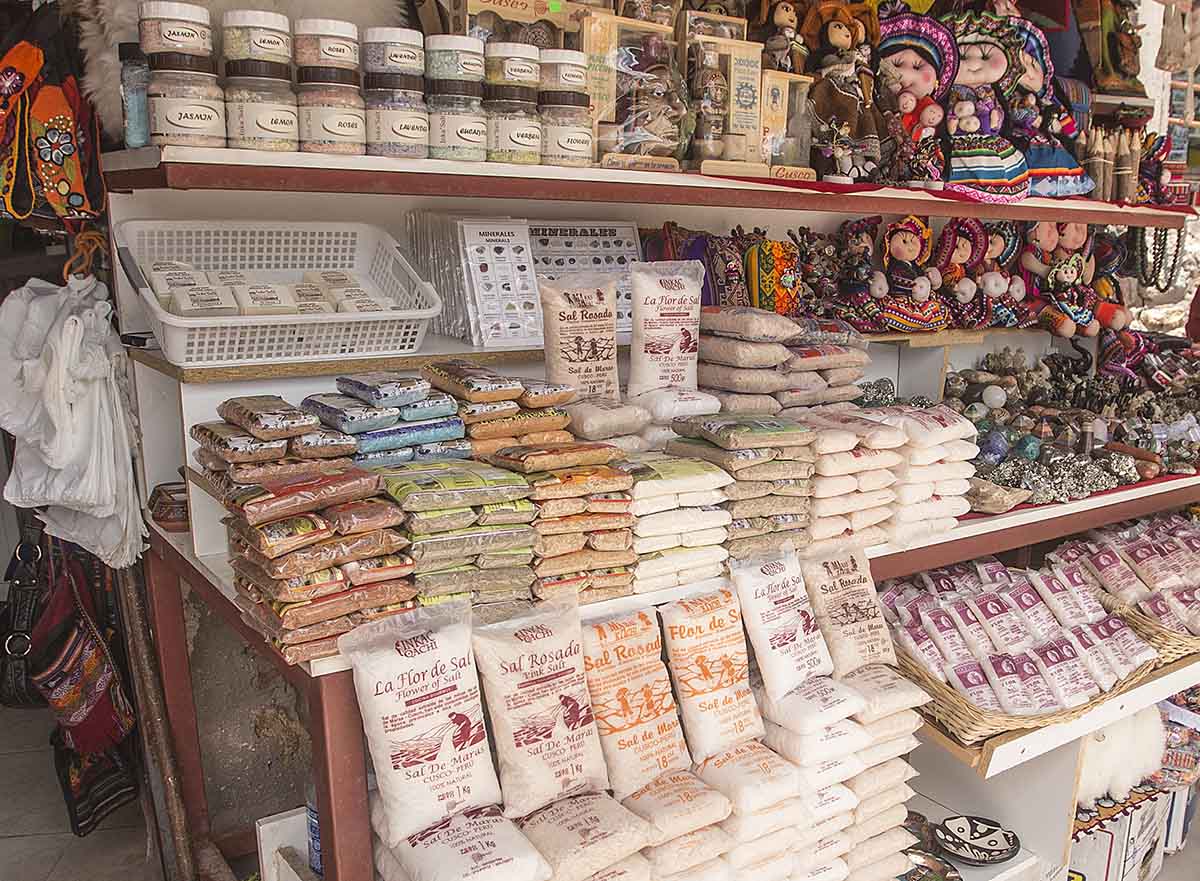 A shop with bags of Peruvian salt from Maras, including white and pink salt, mixed herbs and spices.