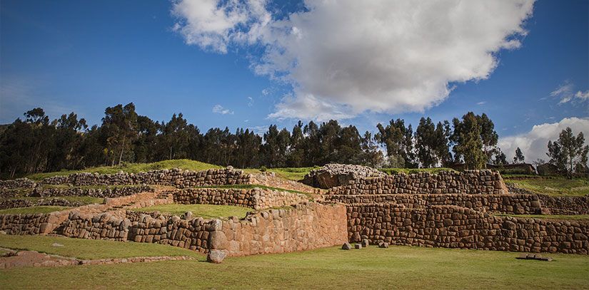 Ruins that display sophisticated Inca stone work located in the lush Sacred Valley of Peru with blue skies and clouds